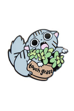 Load image into Gallery viewer, Enamel pin of a cat holding plants with 'touch grass' text on a white background
